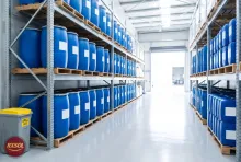 Blue 210 litre drums and jerry cans of heavy oil sludge cleaner on steel racking in our Barka warehouse, Oman